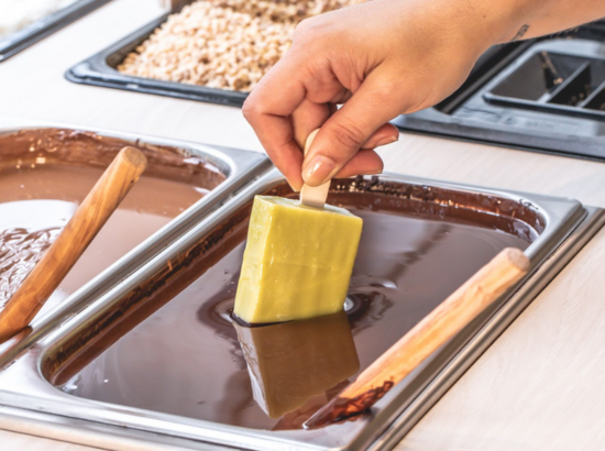 PERSONA SUMERGIENDO UN POLO EN CHOCOLATE